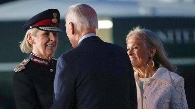 Mr Biden is greeted by Ms Tolhurst as Ms Hartley watches on Sunday night. AP