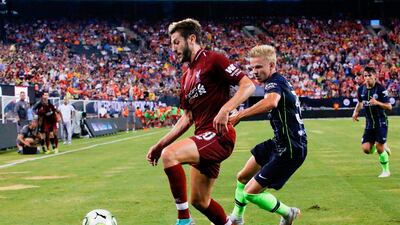 Liverpool's Adam Lallana holds off Manchester City's Oleksandr Zinchenko. AFP