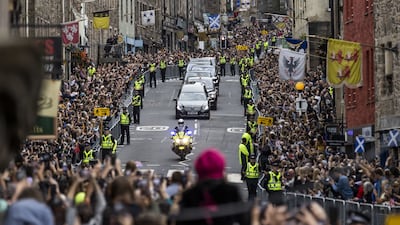 Members of the public gather on the Royal Mile in Edinburgh to watch the hearse carrying the coffin of Queen Elizabeth to the Palace of Holyroodhouse. PA