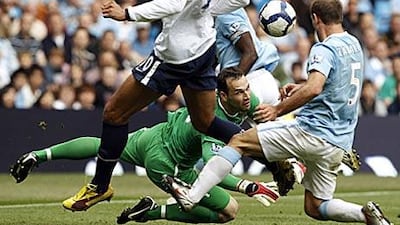 Marton Fulop, the Manchester City keeper, dives through the crowd to palm the ball away.