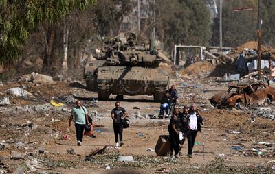 Palestinians fleeing the north through the Salaheddine road in the Zeitoun district on the southern outskirts of Gaza city walk past Israeli army tanks in November. AFP