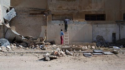 Syrian men walk through a devastated part of the old city of Homs, Syria. Hassan Ammar / AP