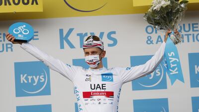 Tadej Pogacar celebrates on the podium in the best young rider's white jersey.