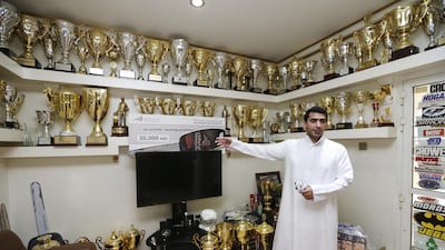 Emirati police officer Sultan Al Zaabi with his haul of drag-racing trophies in his garage in Ajman. Sarah Dea / The National