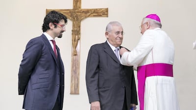 Samir Salloum, centre, and his son Ziad, receive their Vatican knighthoods at St Joseph’s Cathedral in Abu Dhabi. Reem Mohammed / The National