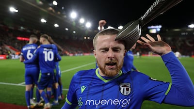 Grimsby's English defender Niall Maher is hit by an inflatable fish as he celebrates. AFP