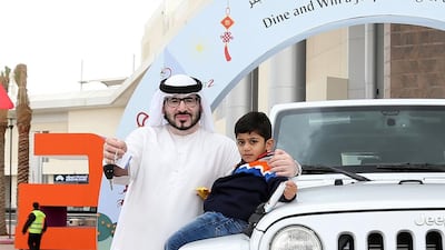 Three year old Khalifa, accompanied by his father Humaid, with his new Jeep Wrangler, courtesy of Nakheel and Dragon Mart. Courtesy Nakheel