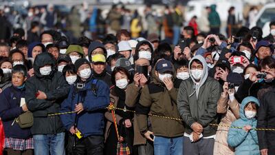 People wear protective face masks following the outbreak of the coronavirus disease as they try to watch the Olympic cauldron during the Tokyo 2020 Olympic's Flame of Recovery tour in Ishinomaki, Miyagi prefecture, Japan. Reuters