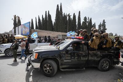 Syrian security forces escort a convoy of SDF fighters out of Aleppo. EPA