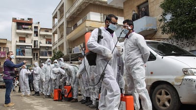 Members of the Syrian Violet NGO prepare to disinfect the Ibn Sina Hospital in Idlib on March 19, 2020. AFP