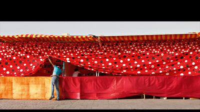A man peeks behind the tarp at a carnival-like stand. Jeffrey E. Biteng / The National