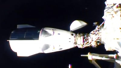 Nasa's SpaceX Crew-1 mission aboard the SpaceX Crew Dragon, right, is docked to the International Space Station. Nasa TV / AFP