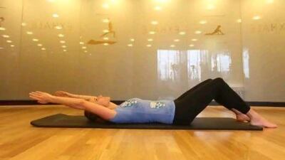 Start by lying down, knees bent, with your arms extended straight above your head. Lee Hoagland / The National