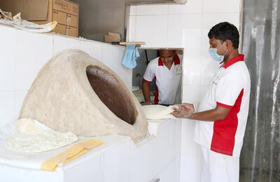 Mohammed Khan and Mohammed Shamshed bake bread at Dar Al Muwaihat Bakery & Restaurant on Sheikh Ammar street in Ajman. Pawan Singh / The National