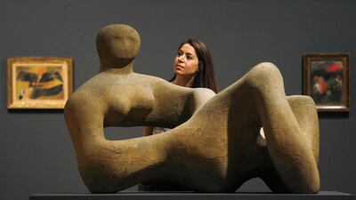 A gallery staff member poses behind Recumbent Figure by Henry Moore before the press view of the Kenneth Clark: Looking for Civilisation exhibition at Tate Britain in London on May 19, 2014. The exhibition looks at Clark’s role as patron, collector, art historian, public servant and broadcaster, and how he helped shape the course of British art. Suzanne Plunkett / Reuters