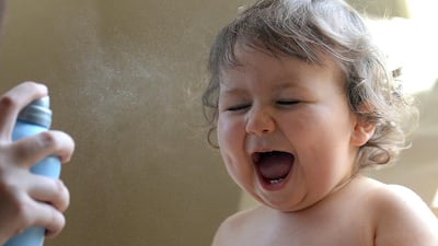A mother cools off her baby with an atomizing water spray in Strasbourg, eastern France, on June 9, 2014, as temperatures remain high in the Alsace region. AFP