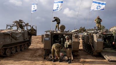 Israeli soldiers work on armoured military vehicles along the border with the Gaza Strip. AP