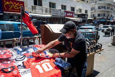 A street seller arranges football shirts at his roadside stand in Amman. AFP