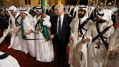 Donald Trump holds a sword and sways with traditional dancers during a welcome ceremony in Riyadh. Evan Vucci / AP Photo