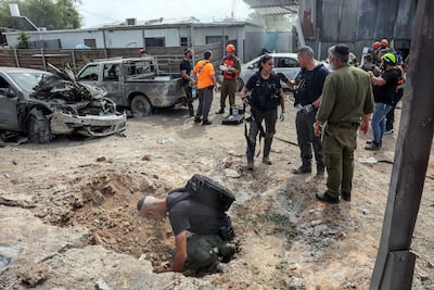 A security official investigates a crater in Kfar Chabad, Israel, after Hamas's armed wing said it attacked Tel Aviv with a missile salvo. Reuters