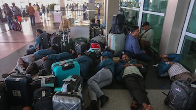 Passengers rest outside Terminal 1 of New Delhi's Indira Gandhi International Airport after mass cancellation of Indigo flights on December 5, 2025. Getty Images