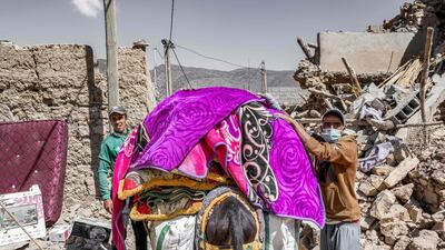 Residents load a donkey with blankets. AFP