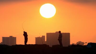 A fisherman casts his line from the rocks at Seal Beach, California, as the sun prepares to set. AFP