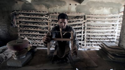 An Egyptian worker shapes a clay ornament at one of the traditional pottery workshops, in Old Cairo, Egypt.