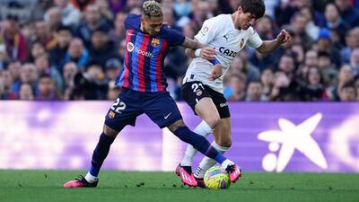 Barcelona's Raphinha fights for the ball with Valencia's Vazquez Alcalde. EPA