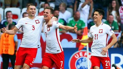 Arkadiusz Milik, centre, celebrates his goal for Poland against Northern Ireland. Oliver Weiken / EPA