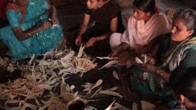 Lakshmi Dhule (top left) shows village women how to make flower ornaments from dried banana leaves.