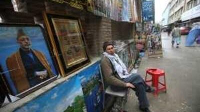A stallholder sells pictures, including some of Hamid Karzai, at a roadside in Kabul.