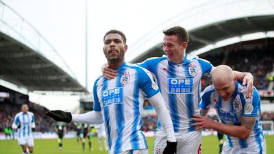 Huddersfield Town’s Steve Mounie celebrates scoring their third goal with Jonathan Hogg and Aaron Mooy. Jason Cairnduff / Reuters