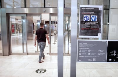Early Ramadan shoppers at Carrefour Yas Mall are told to wear gloves and mask before entering. Victor Besa / The National