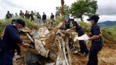 Investigators examine a TV van at the site of the massacre of 57 people in Maguindanao in November.