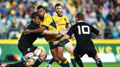 Richie McCaw of New Zealand, left, tries to hold back Australia’s Kurtley Beale, right, during the opening game of the Bledisloe Cup series at the ANZ Stadium in Sydney. Paul Miller / EPA