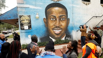 People gather in front of a mural of Ahmaud Arbery painted on the side of The Brunswick African-American Cultural Centre in Brunswick, Georgia. Reuters
