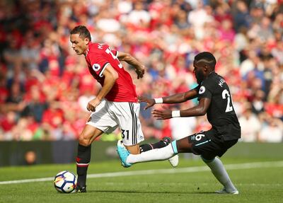 Manchester United's Nemanja Matic, left, gets past West Ham United's Arthur Masuaku. Dave Thompson / AP Photo