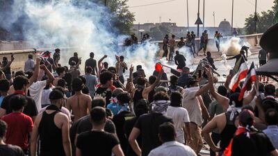 Protesters stand amid tear gas fumes as they clash with Iraqi riot police between the capital Baghdad's Tahrir Square and the high-security Green Zone district. AFP