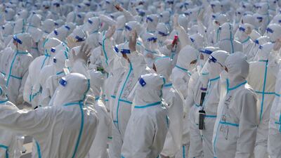 Medical workers in protective suits wave at Changchun residents during a farewell ceremony before returning to Meihekou, where they were sent from to help curb the Covid-19 outbreak in Jilin province, China. Reuters