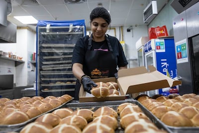 Anna Rodrigues packs an order at the Golden Chariot, her family-run bakery in Dubai's Karama, that weathered a dip in demand during the Iran war with orders from loyal customers. Antonie Robertson / The National