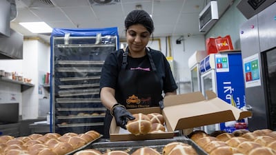 Anna Rodrigues packs an order at her family-run Golden Chariot bakery in Karama. The store had more than 1,000 freshly baked goods for Good Friday and nowhere to supply to when church services were cancelled until people in Dubai snapped up the food. Antonie Robertson / The National