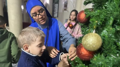 A child adds an ornament to a Christmas tree at the Holy Family Church. Photo: Holy Family Church Gaza