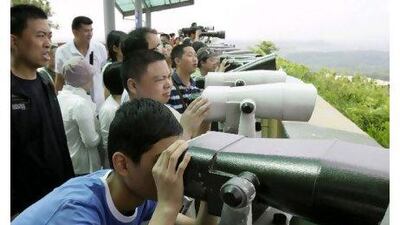 Tourists look north through binoculars at the Dora Observation Post in Paju near the truce village of Panmunjom in the demilitarized zone (DMZ) that separates the two Koreas. Lee Jin-man / AP Photo
