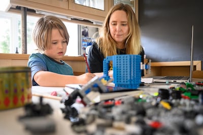 James Laurie, aged 8, is assisted in his online work by his mother Laurette as he continues home-schooling in London. From bearing the larger burden of home-schooling to facing elevated levels of job losses, women have suffered throughout the past year. Getty Images