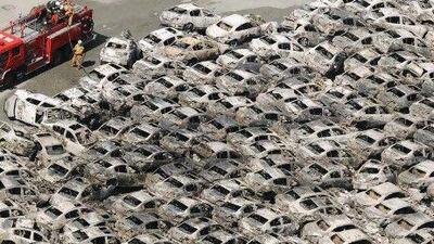A firefighter looks at burned-out vehicles at Hitachi port one day after a giant quake and tsunami struck the country's northeastern coast. AP Photo