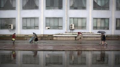 Pedestrians walk along a sidewalk on a rainy evening in Pyongyang, North Korea. Amid rising regional tensions, Pyongyang residents have been preparing for North Korea’s most important holiday: the 105th birth anniversary of Kim Il Sung, the country’s late founder and grandfather of current ruler Kim Jong Un. Wong Maye-E / AP