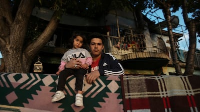 A Syrian father and daughter stand in front of their shelter in Ulus district in Ankara, Turkey. Hundreds of Syrian men and boys were detained, beaten and forcibly returned to their country by Turkish authorities over a six-month period, a leading human rights group has said. The Turkish government has in the past rejected accusations of forcibly returning refugees to Syria. AP