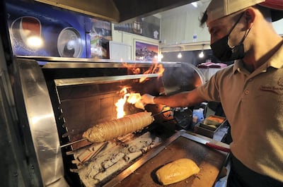 A vendor at Global Village prepares Turkish delicacy kokorec. Chris Whiteoak / The National