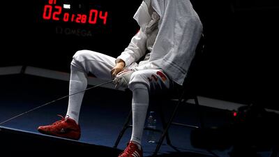 China's Lei Sheng waits as Egypt's Alaaeldin Abouelkassem (not seen) receives medical assistance during their men's individual foil gold medal fencing match at ExCel. Fabrizio Bensch/Reuters